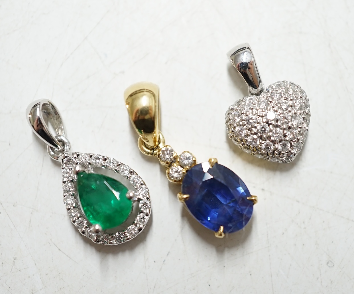 Three assorted modern 18k and gem set small pendants, including heart shape diamond cluster, gross weight 4.5 grams. Condition - fair to good